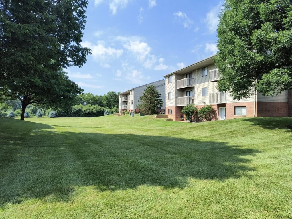Sunny day at Windsor Place apartment complex with lush green lawns in Beavercreek, Ohio.